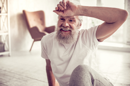 So pleased. Handsome mature man expressing positivity while relaxing after exercisesの写真素材