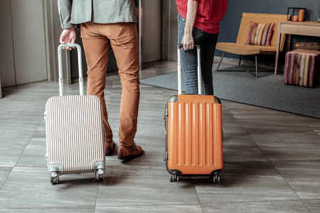 My support. Cheerful stylish man wearing casual clothes and leaning on his luggageの写真素材