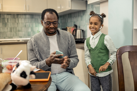 Turning music on. African-American loving father turning music on for his cute daughterの写真素材