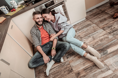 Happy man. Handsome bearded man feeling happy sitting near his appealing cheerful girlfriendの写真素材