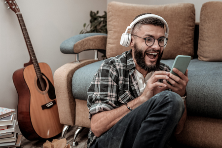 Favourite music. Happy excited man smiling while listening to his favourite songの写真素材