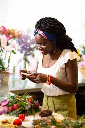 For good memory. Positive delighted woman keeping smile on her face while looking downwards at decorの写真素材
