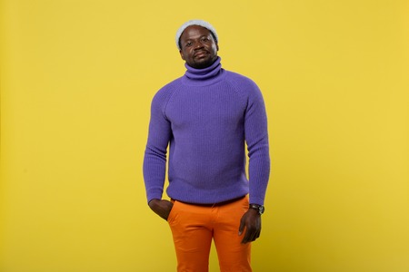 Look at me. African freelancer wearing colorful clothes and standing over yellow backgroundの写真素材