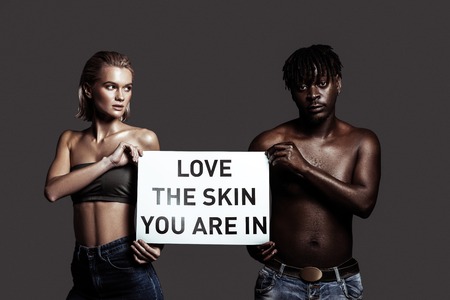 Love your skin. Models having different colors of skin supporting diversity asking people to love their skinの写真素材