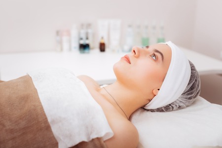Body treatment. Nice young woman waiting for a cosmetologist while having a procedure for bodyの写真素材
