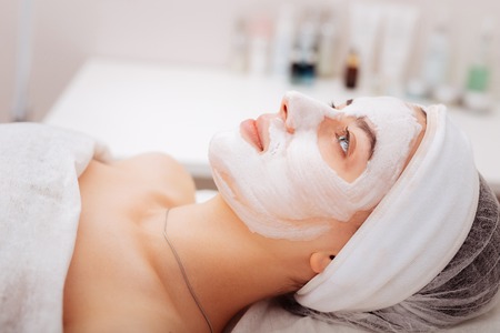 Shiny skin. Pleasant young woman lying with a facial mask while wanting to have shiny skinの写真素材