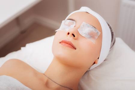 Relax for eyes. Positive joyful woman smiling while enjoying the beauty procedureの写真素材
