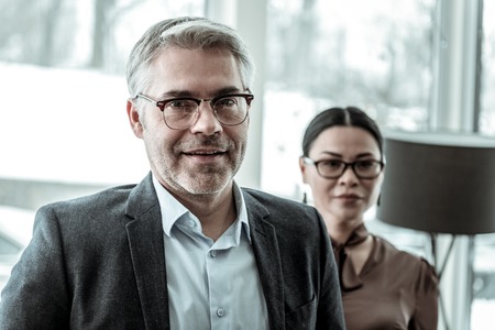 Smiling lady. Brunette adult businesswoman wearing a brown satin blouse smilingの写真素材