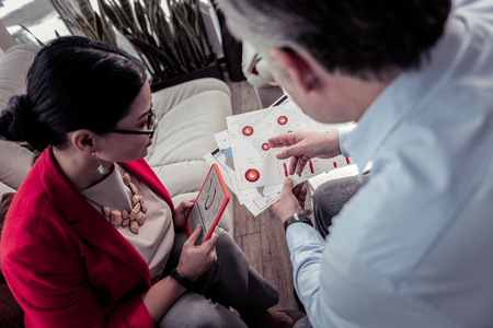 New start. Brunette businesswoman wearing a red jacket analyzing the project detailsの写真素材