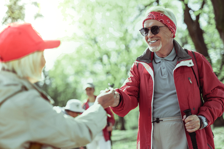 Active weekends. A stylish elderly man walking in forest with his partnerの写真素材