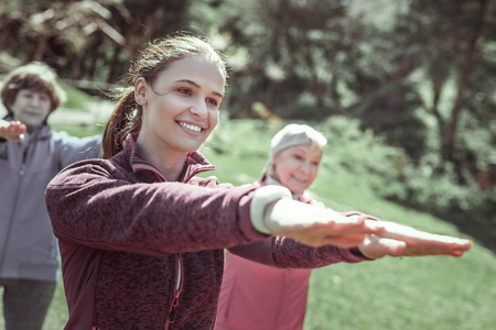 Cute lady. Cute sportive lady laughing while watching straight during exercise on shouldersの写真素材
