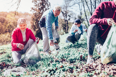 Litter in park. Couple of retired people feeling active and responsible while gathering litter in the parkの写真素材
