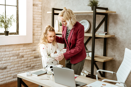 Unreasonable tantrum. Caring short-haired mother settling down her daughter feelings after harsh and angry conversationの写真素材