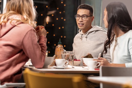 Movie impressions. In restaurant wavy-haired girl in pink telling her two close friends about the movie she watching.の写真素材