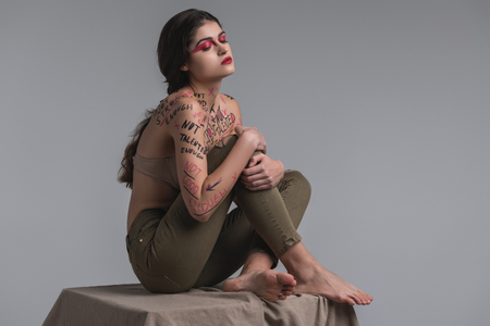 Nice model. Long-haired cute young model with body art wearing a beige bra posing for the cameraの写真素材