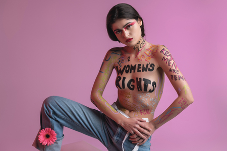 Photoshoot. Young brunette pretty half-naked model wearing blue jeans taking part in a photoshootの写真素材
