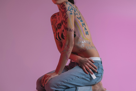 Nice pose. Young brunette pretty half-naked model wearing blue jeans leaning forwardの写真素材