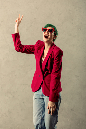 Posing for a photo. Joyful nice woman smiling while showing a V signの写真素材