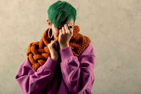 Being shy. Pleasant nice woman hiding her face while being shyの写真素材