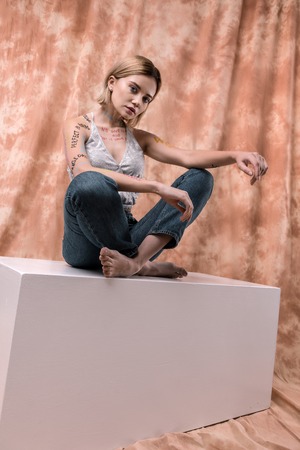 Professional photo shoot. Beautiful pretty woman sitting in front of the camera while posing for a photoの写真素材