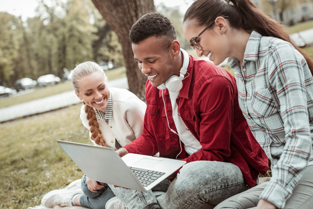 Friendly atmosphere. Delighted man expressing positivity while communicating onlineの写真素材