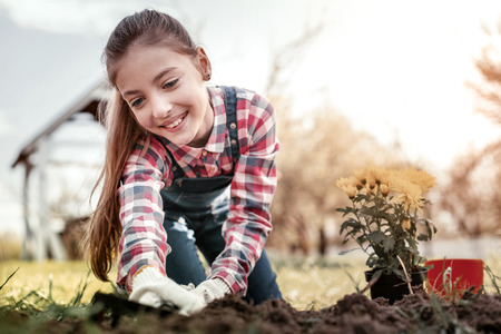 Girl with big ears. Beautiful smart girl with big ears loving what doing with land and plants at...