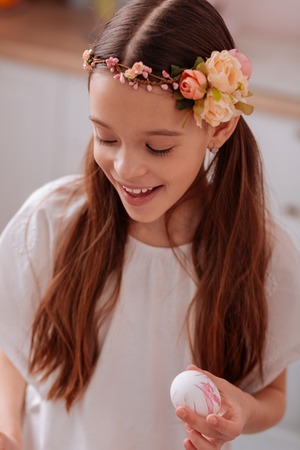 Ready for celebration. Beautiful brunette girl having romantic hairstyle and demonstrating her sincere emotionsの写真素材