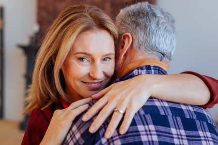 Green-eyed woman. Beautiful mature green-eyed woman hugging her supportive man after nice eveningの写真素材
