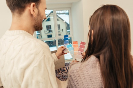 Colors bedroom. Loving stylish husband and wife discussing and choosing colors for their bedroom