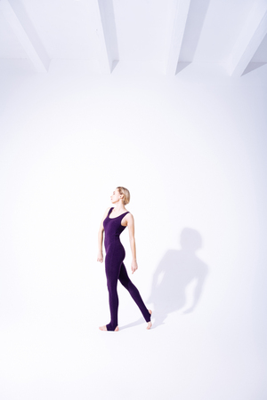 Professional gymnast. Beautiful slim woman walking while having a professional trainingの写真素材