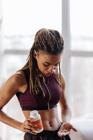 Vitamins and supplements. Woman leading healthy lifestyle drinking vitamins and supplements in the morningの写真素材