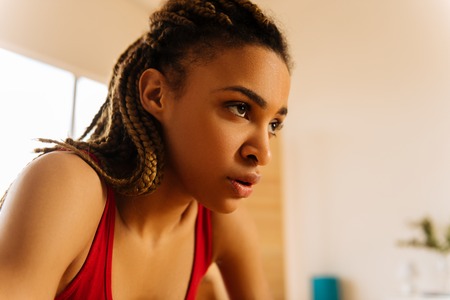 After intensive workout. Young dark-eyed woman with nice braids hardly breathing after intensive workoutの写真素材