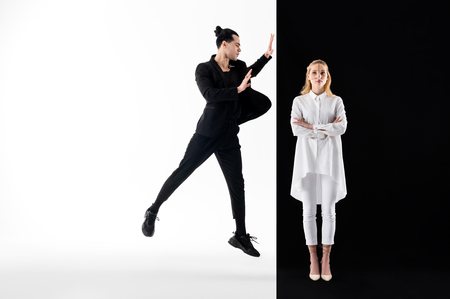 Male and female. Male model wearing black suit and female model in white posing together in yin and yang imagesの写真素材