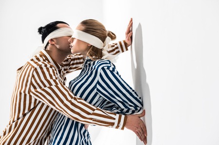 Shirts and blindfolds. Young creative models wearing striped shirts and blindfolds posing together