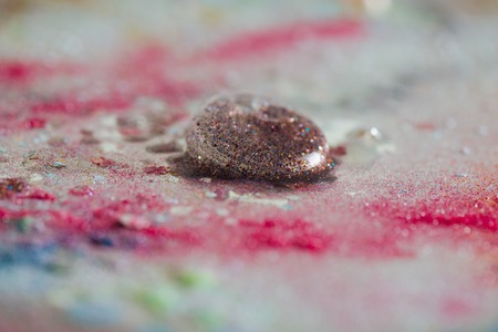 Brightly sparkling . Beautiful colorful bubble with glitter inside leaved on a dirty table with mess...