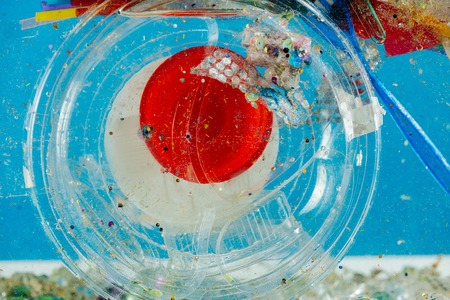 Disgusting harmful pile . Transparent plastic container and packages lying in bunch of garbage and glitter piecesの写真素材