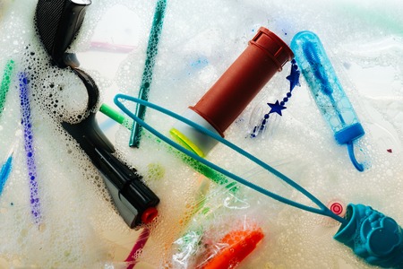 Bubbled soapy liquid. Plastic trash for kids made of harmful materials and thrown into soap and waterの写真素材