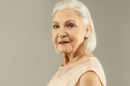 Pleasant smile. Portrait of a joyful positive aged woman smiling to you