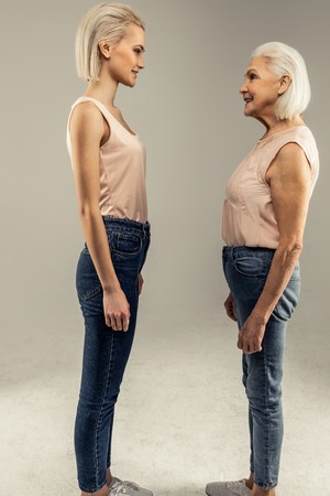 My future. Nice positive woman smiling while looking at herself being old