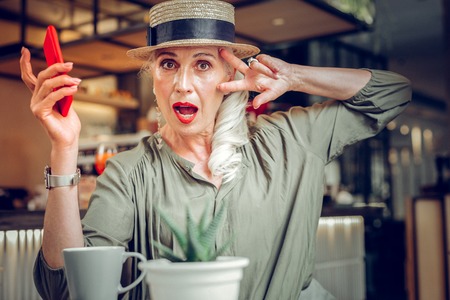 Time to relax. Nice good looking woman having fun while sitting in the cafeの写真素材