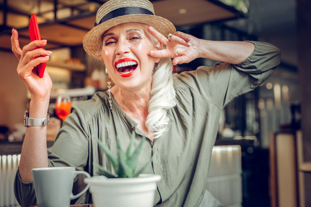 Great mood. Delighted good looking woman showing her positive emotions while resting in the restaurantの写真素材