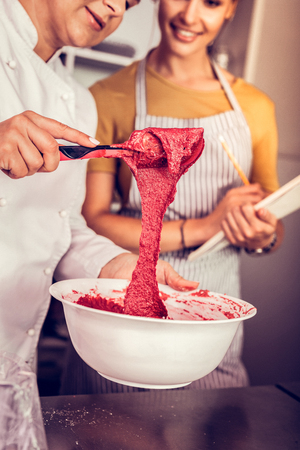 Let me check. Cute girl wearing apron while visiting professional workshopの写真素材