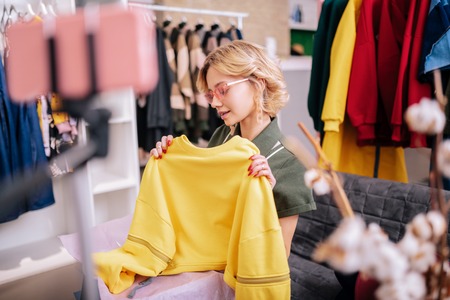 Blog about clothes. Young stylish blonde-haired woman in nice sunglasses filming blog about clothesの写真素材