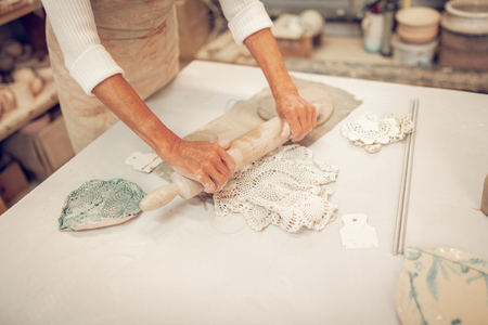 Beautiful napkin. Top view of a crocheted napkin lying on the table while being used in the clay workshopの写真素材