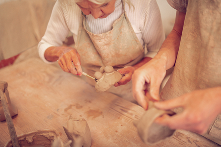 Interesting design. Nice aged woman standing at the table while creating an interesting design for the bowlの写真素材