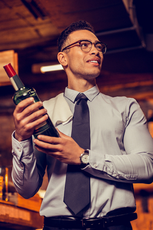 Excited businessman. Excited businessman wearing tie holding bottle of alcohol opening his barの写真素材