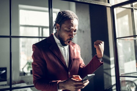 Feeling happy. Bearded stylish businessman feeling happy after receiving working e-mail