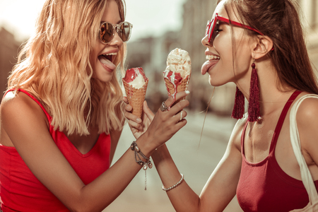 Women with ice-creams. Two beautiful alluring charming delightful young-adult sensuous beauties...