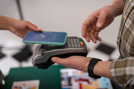 A successful payment. Close-up shot of a customer doing a successful payment via PayPass on the smartphone.の写真素材