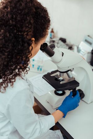 New scientific research. Intelligent female biologist sitting in the lab while working on her projectの写真素材
